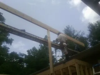 Carpenter setting a ridge beam over a new addition frame — Ice Dam Removal by Roofing Brothers in Harleysville