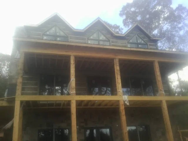 Dormers and porch framing on a large log home under construction — Roof Coating work by our crew in Harleysville