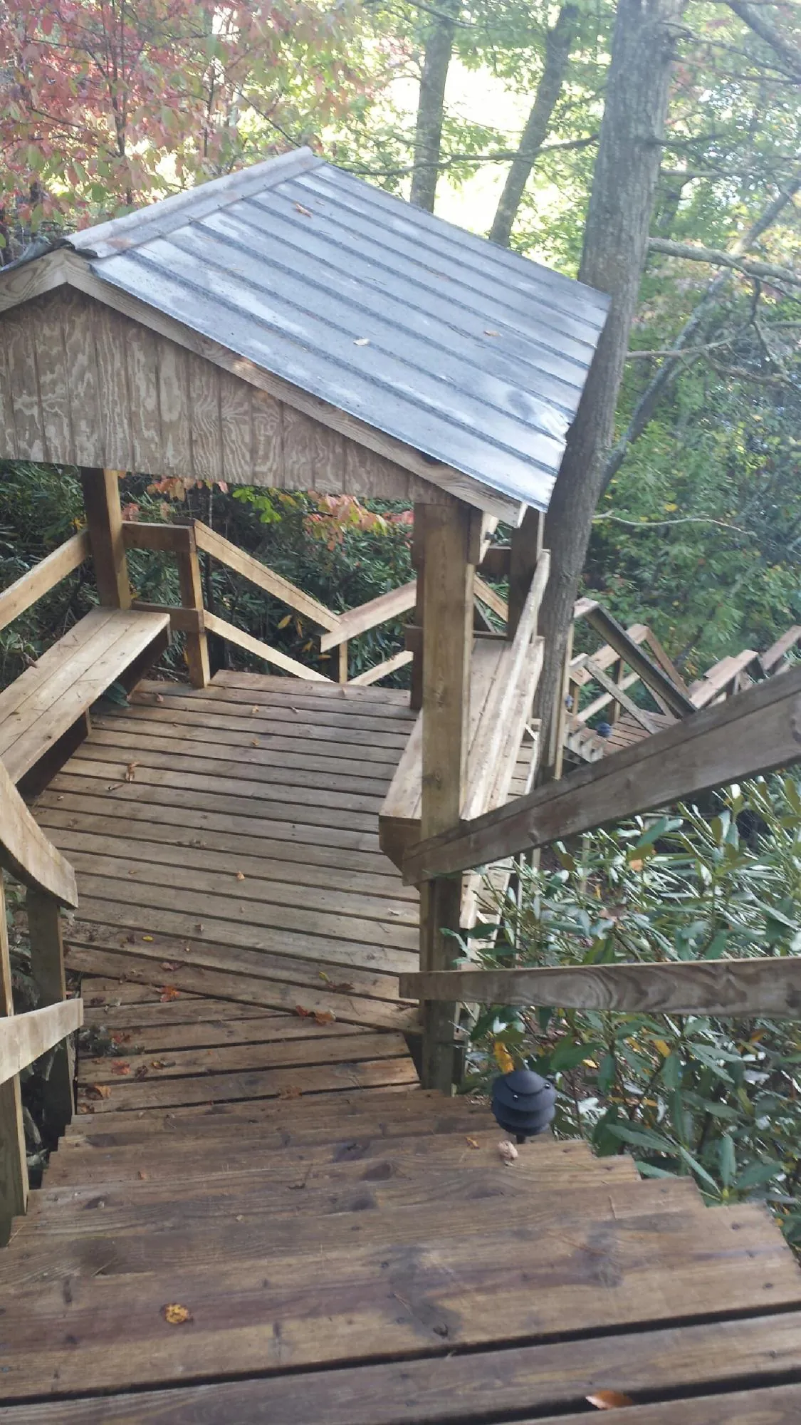 Metal roofed shelter over wooden steps on a wooded walkway — Skylight Repair & Installation work by our crew in Harleysville